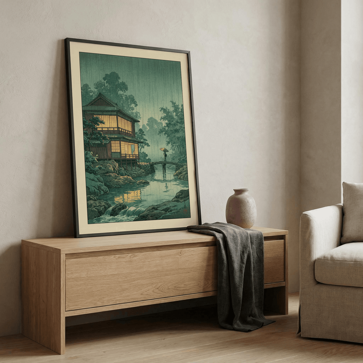 Japanese Landscape wall art leaning on a wooden sideboard with a ceramic vase and grey cloth in a living room