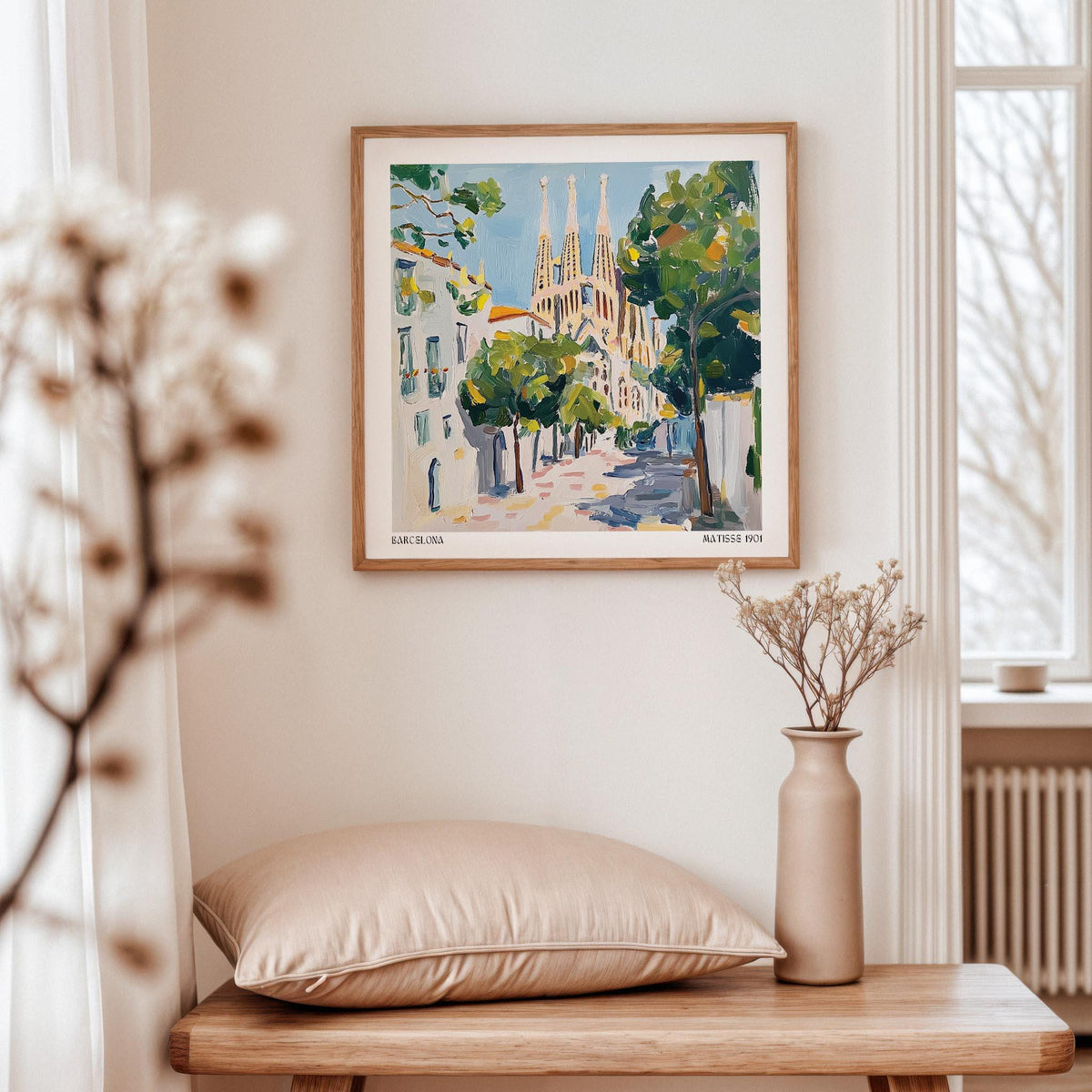 Barcelona Boulevard Poster print of Sagrada Familia church with green trees by a window above a shelf with a vase and cushion