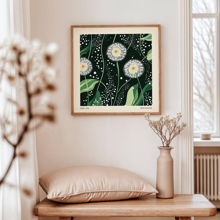 Green wall decor of dandelion seed heads with green leaves above a wooden bench with a cushion