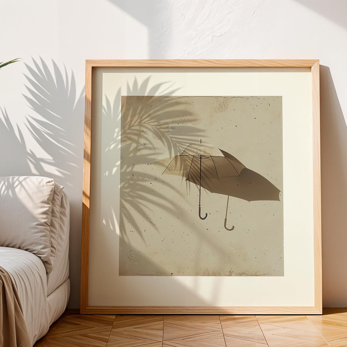 Framed print of an open umbrella with shadow in brown tones leaning on a wooden floor with a sofa nearby