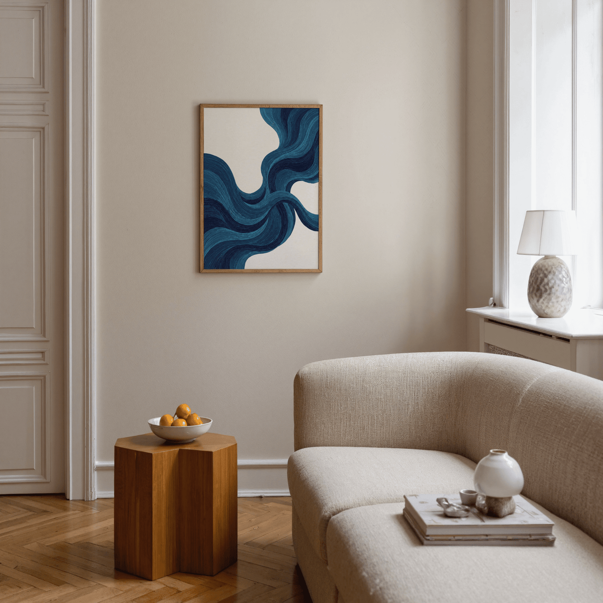 Blue line wall art with flowing blue lines in a neutral living room above a wooden side table