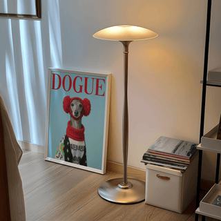 Print of Italian Greyhound wall art leaning on wood floor beside a tall floor lamp and stack of magazines