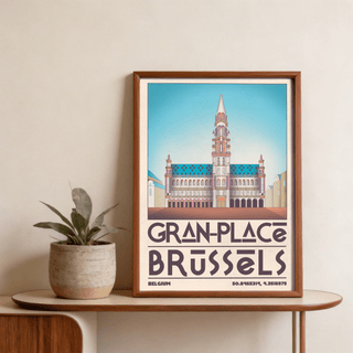 Framed Brussels Grand Place Art Print with blue sky and vintage typography next to a green plant