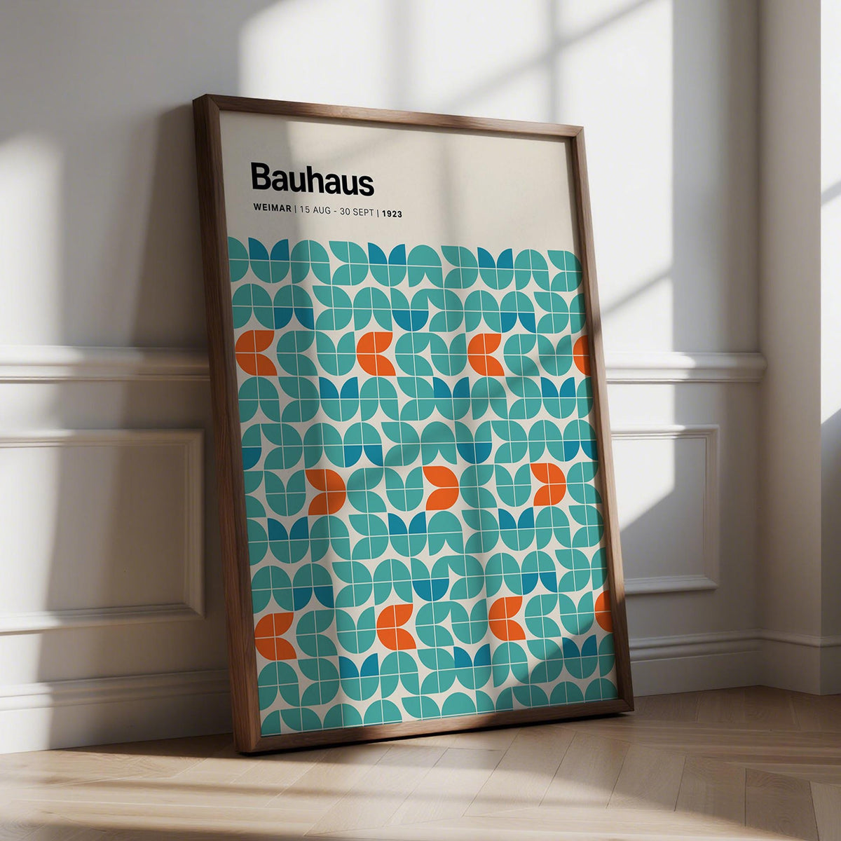 Framed Graphic Wall Art with modular geometric pattern in blue teal and orange leaning on a wooden floor