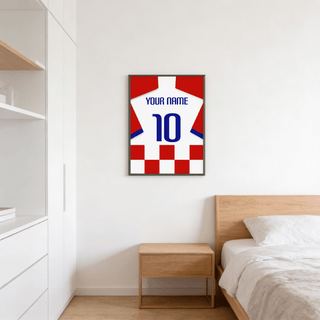 Football shirt poster in red and white checks with blue number above a wooden bedside table