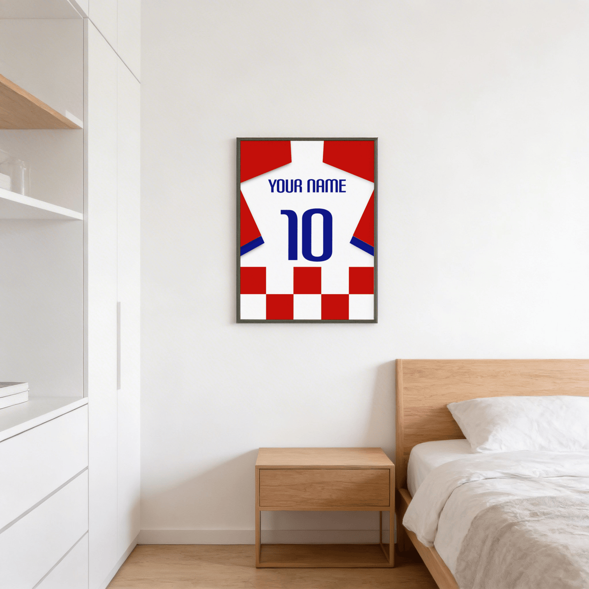 Football shirt poster in red and white checks with blue number above a wooden bedside table