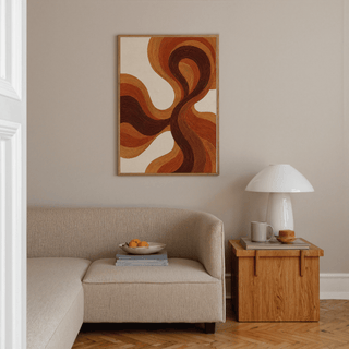 Organic Line Poster in flowing brown and orange lines above a beige sofa with a wooden side table and white lamp