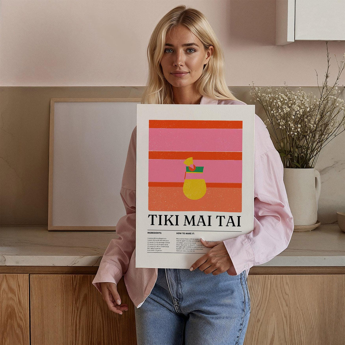 Framed Bar Wall Art held by a woman featuring colourful tiki mai tai cocktail illustration and text