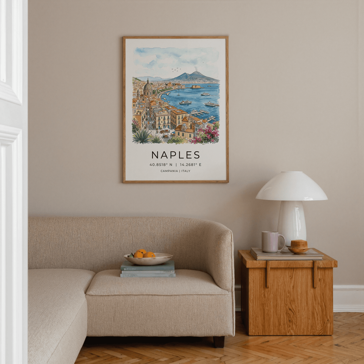 Naples City Art Print on a living room wall above a beige sofa with a side table and lamp