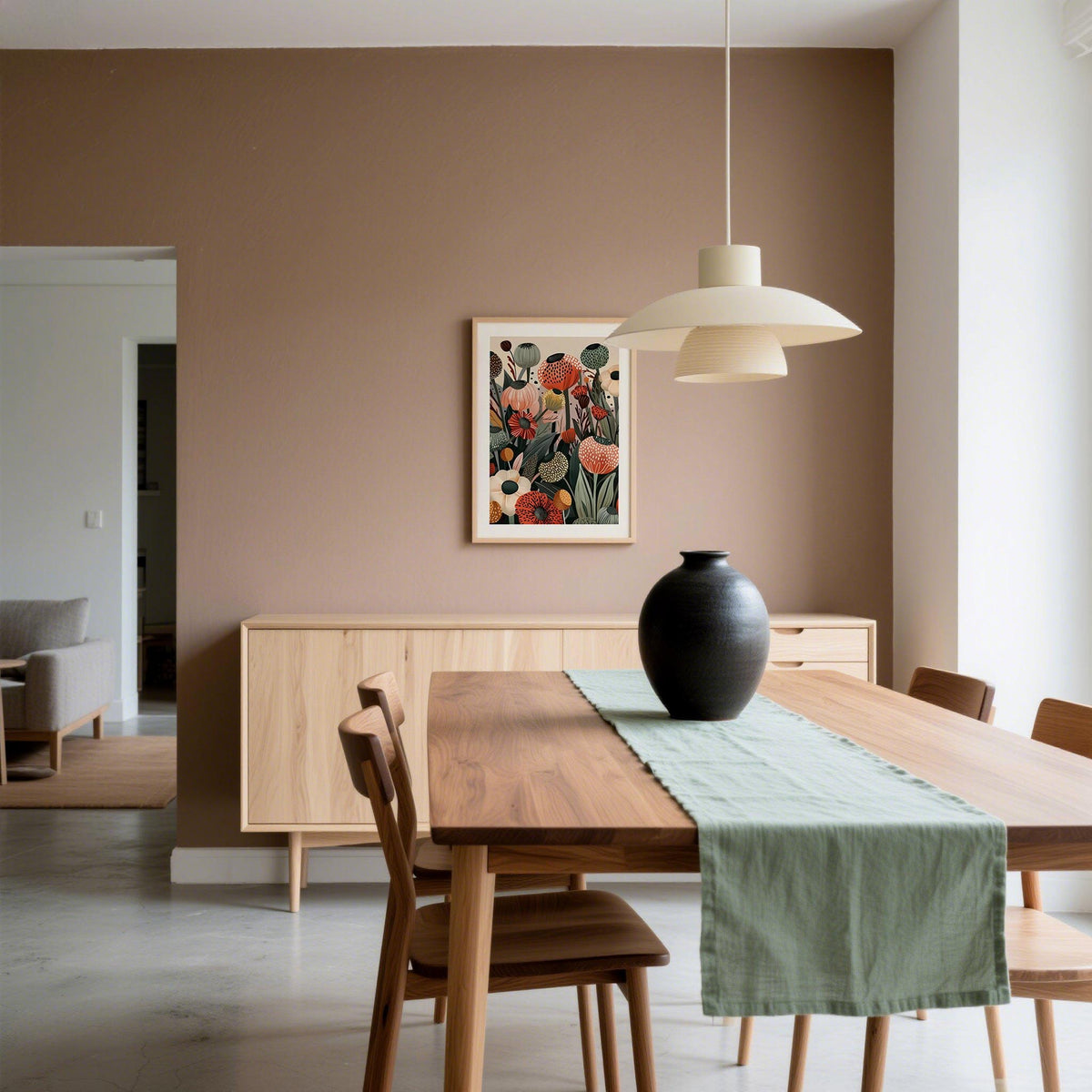 Floral print wall art of poppy seed heads in muted tones hung on a brown wall above a sideboard