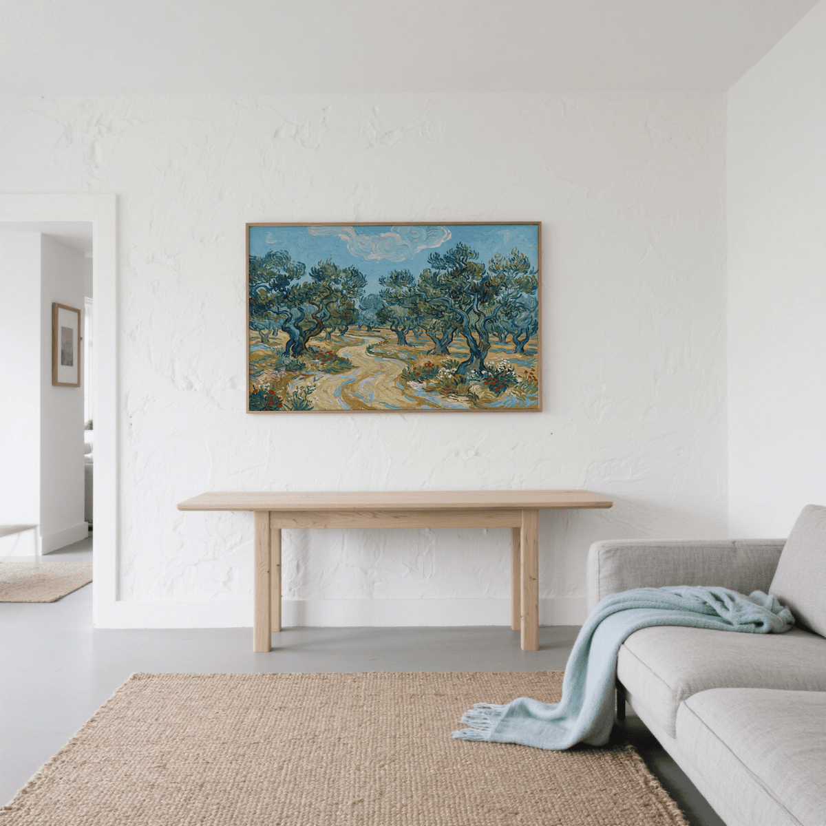 Olive Tree Landscape Print hanging above a wooden bench in a simple white-walled living room