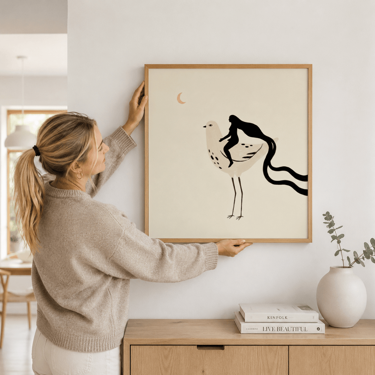 Whimsical Bird Art Print framed print of a woman riding a bird with cream and black tones in a hallway