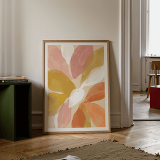Floral Watercolor Art Print leaning on the floor with muted pink and orange petals and a green bookcase nearby