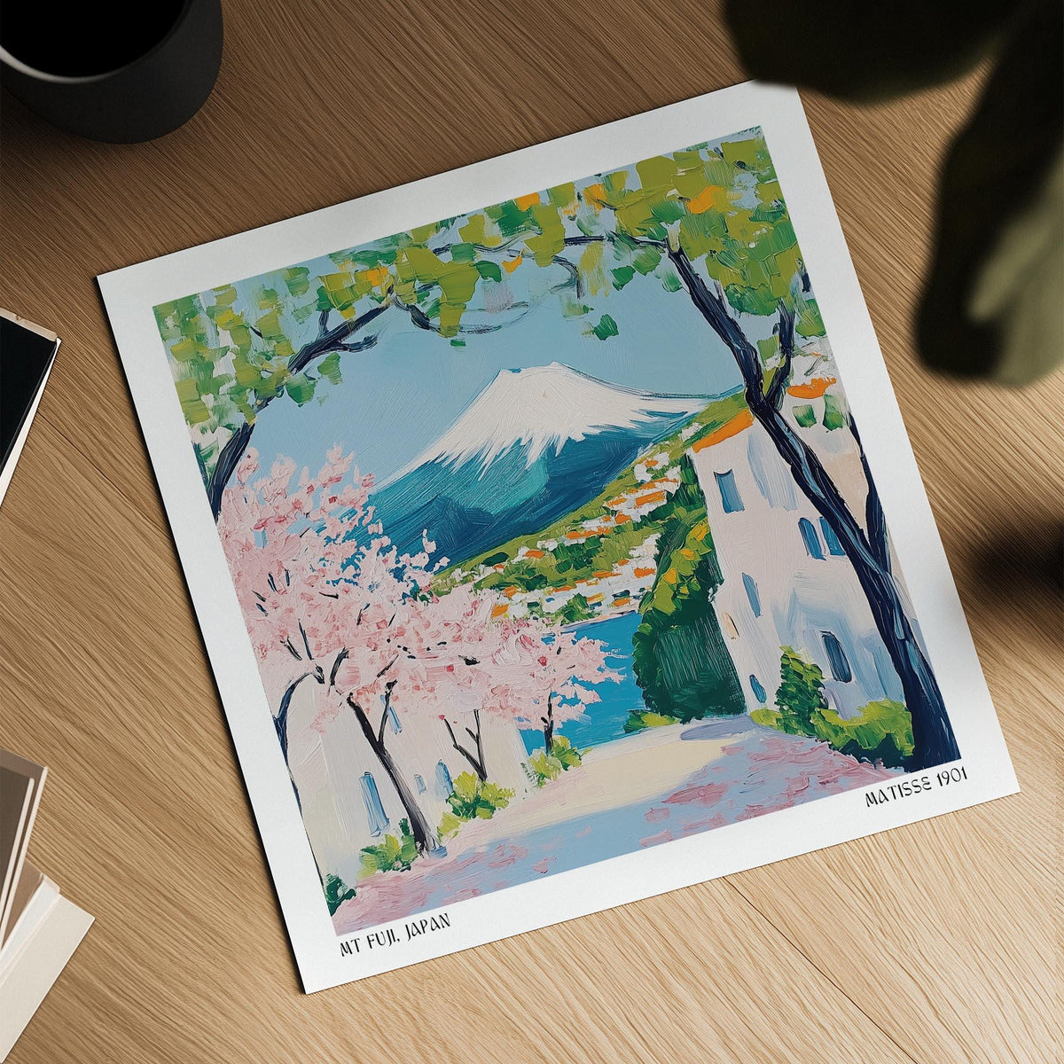 Japan poster laid on a wooden surface showing Mount Fuji with cherry blossoms and greenery
