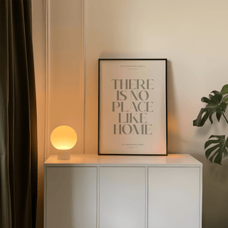 Print on a white sideboard with a glowing spherical lamp and a green plant nearby