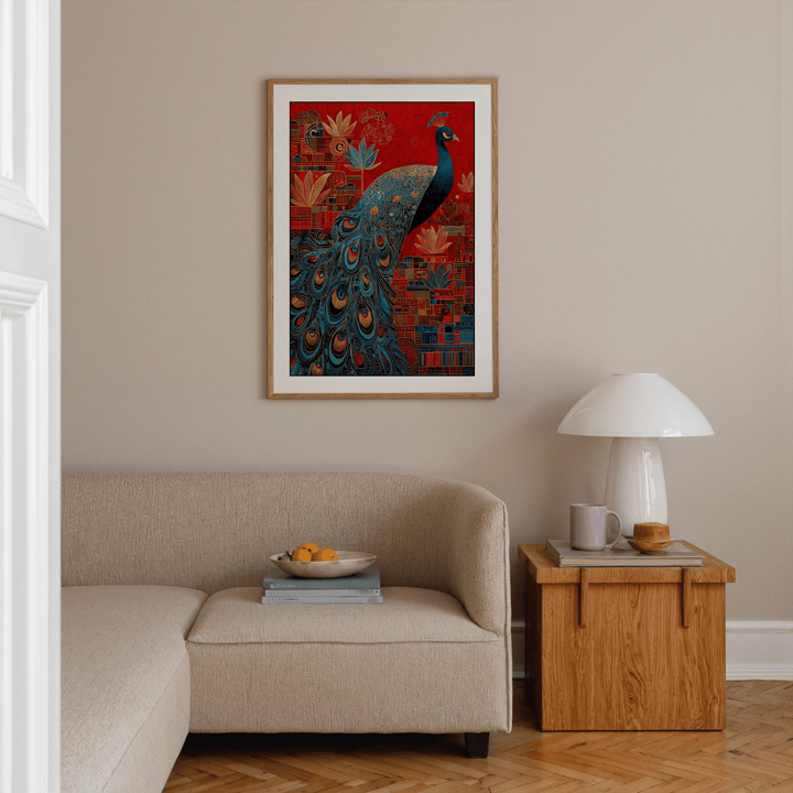 Indian peacock art print with bright blue and red colours hanging above a beige sofa with wooden side table
