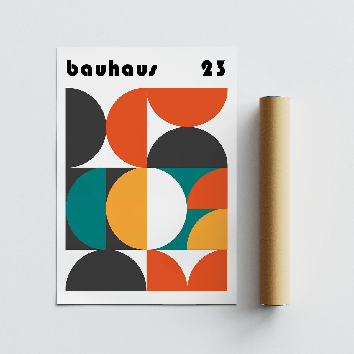 Print of geometric shapes in orange teal black and yellow leaning beside a brown packaging tube
