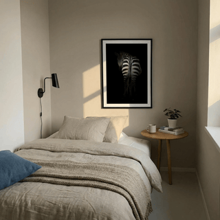 Print on a wall in a bedroom of zebra art print showing the rear view of a zebra with black and white stripes