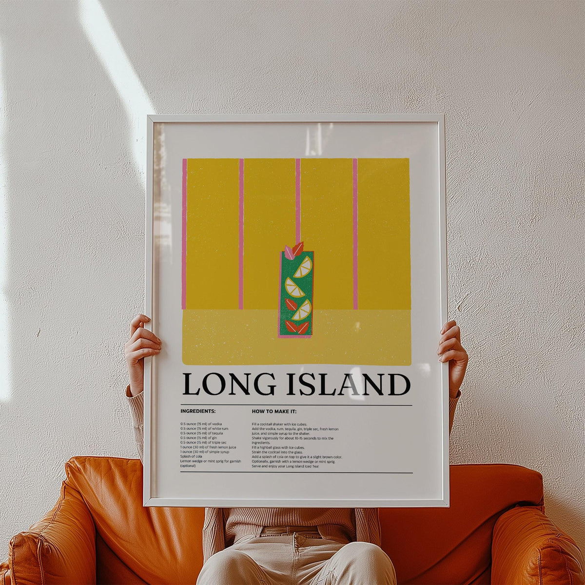 Framed Drink Print of a Long Island iced tea cocktail illustration with yellow and green colours held on a leather sofa