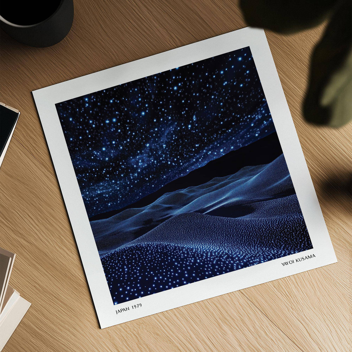 Detail close-up of navy blue artwork showing a starry night sky and textured hills on a wooden surface