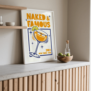 Mezcal Cocktail Art Print leaning on a shelf with orange yellow and blue colours and a wooden bowl with limes nearby
