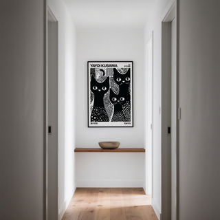 Black Cats Poster of three black cats with white polka dots in a minimalist hallway with a wooden shelf and bowl