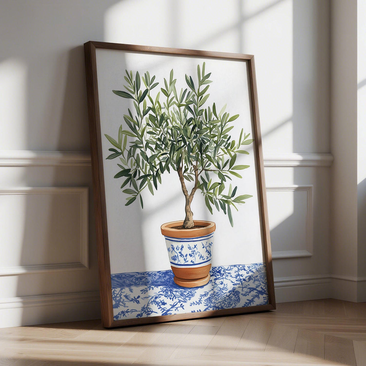 Print leaning on wooden floor olive tree art print in terracotta pot with blue detailing