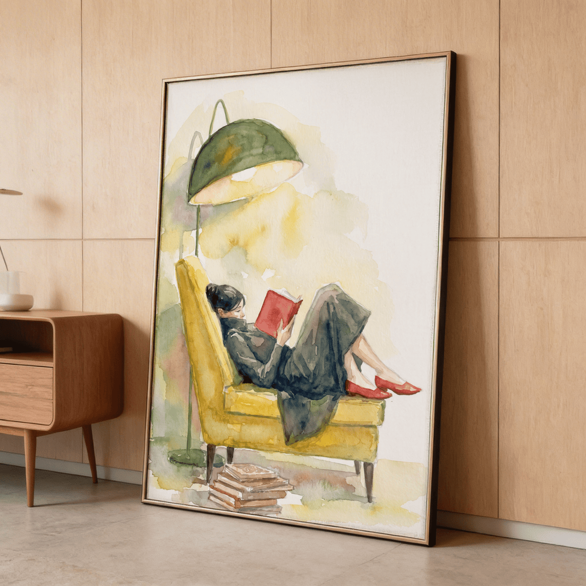 Framed Woman Reading In Armchair Print leaning against wooden wall next to a cabinet