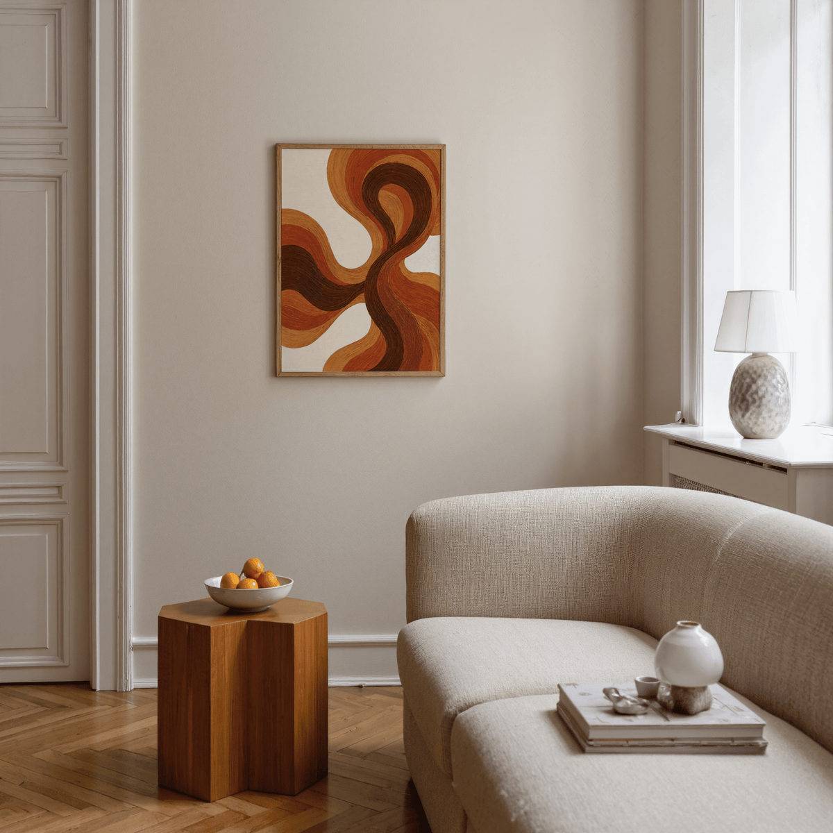 Organic Line Poster on a living room wall with flowing brown and orange lines and a wooden side table with a bowl of oranges