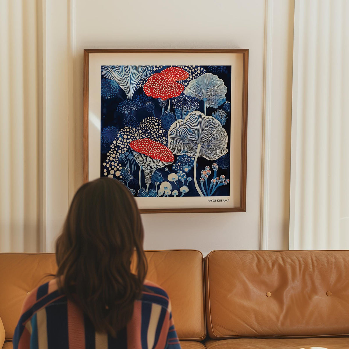 Framed Mushroom Poster wall art of spotted mushrooms in blue and red above a tan sofa in a living room