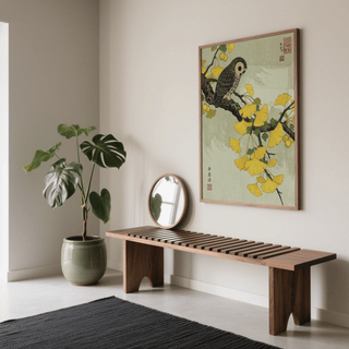 Owl and Ginkgo Print hanging above a wooden bench with a green plant in a neutral room