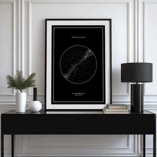 Custom Star Map print with black background and white text on a console with a lamp and plant