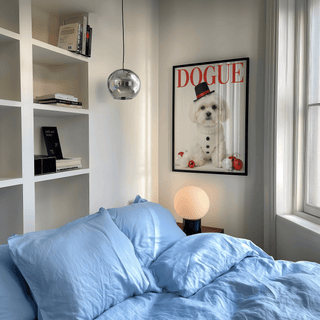 Christmas Shih Tzu Poster on wall above bedside table with round lamp in bedroom