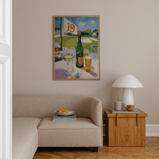 Watering Hole Golf Art Print in a living room above a beige sofa with a wooden side table and lamp