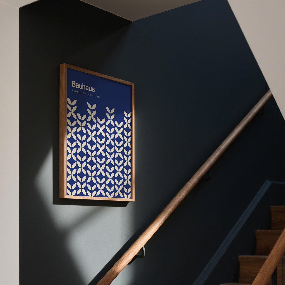 Blue modern wall art with white petal shapes in Bauhaus style on a dark stairway wall