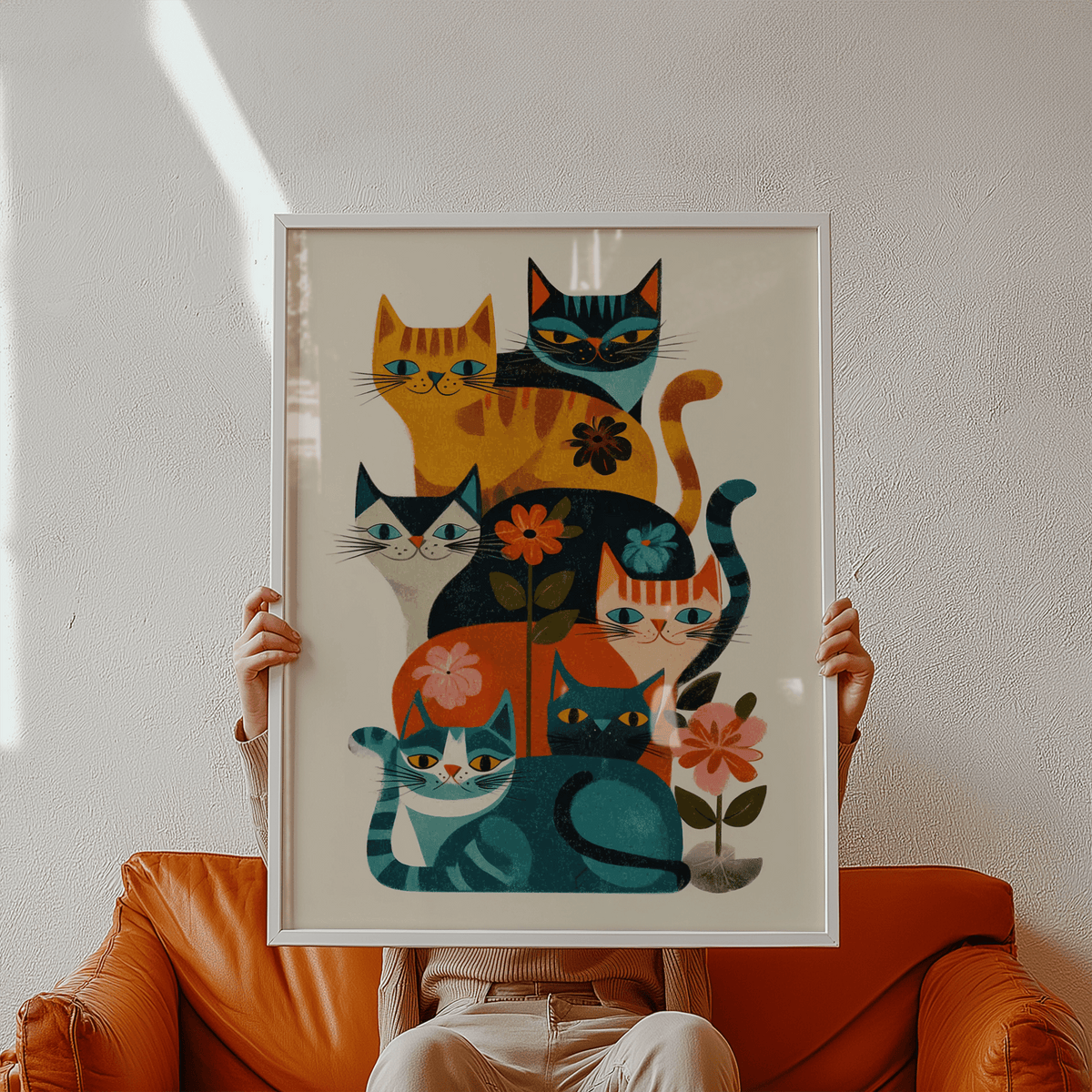 Framed Colorful Cat Wall Art with a group of illustrated retro cats held by a person on a brown sofa