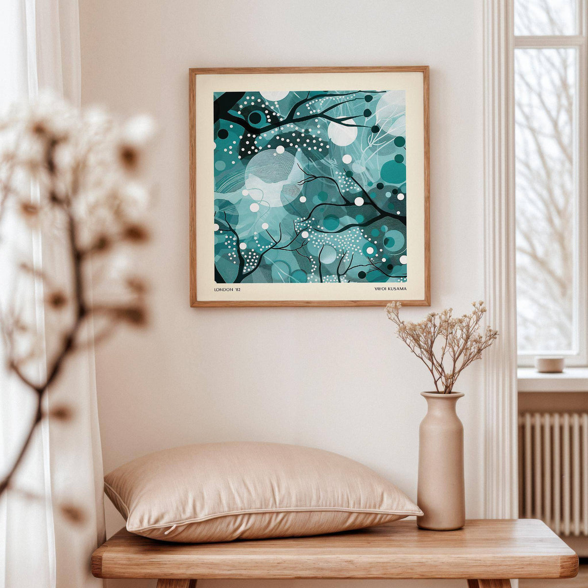 Teal home decor print of abstract moonlit branches above a wooden table with a beige cushion and vase