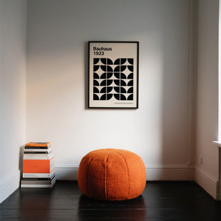 Mid Century Art Prints black and white geometric bauhaus pattern above orange cushion with books on floor