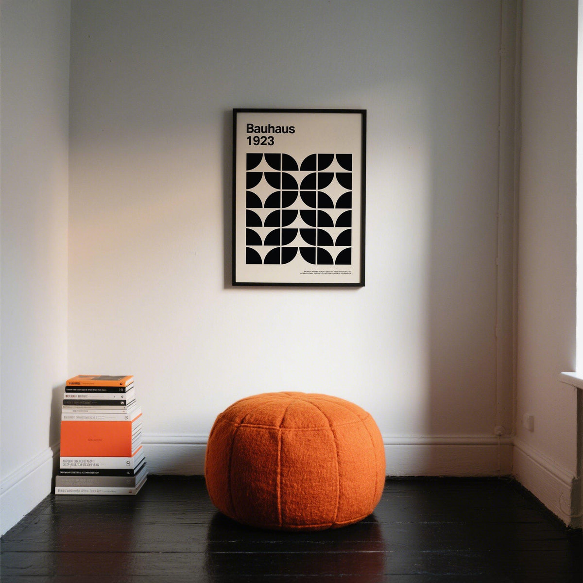 Mid Century Art Prints black and white geometric bauhaus pattern above orange cushion with books on floor