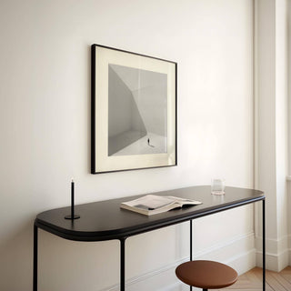 Square Art Prints framed print close-up of a solitary man in minimalist greys above a black console table with a candle and book