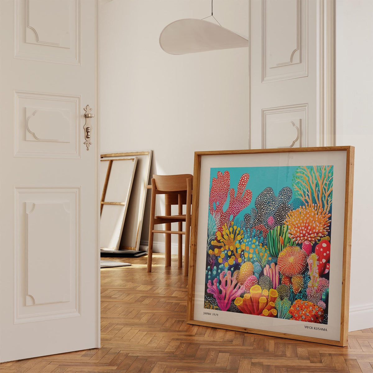 Colorful Ocean Picture leaning on a parquet floor in a room with a wooden chair nearby