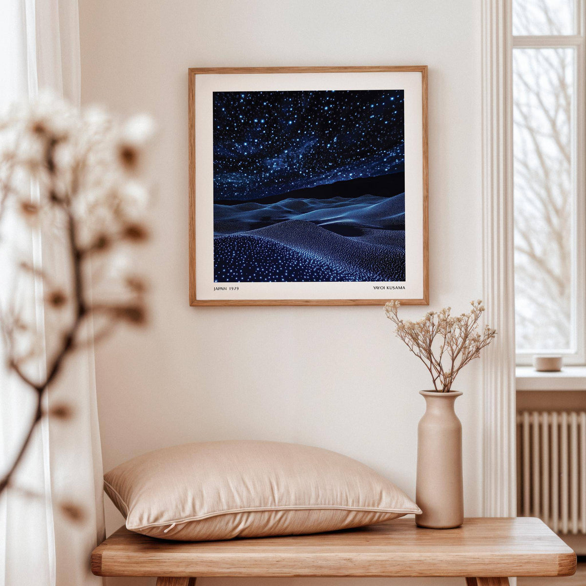 Navy Blue Artwork of a starry night sky above blue dunes in a serene room with a vase of dried flowers