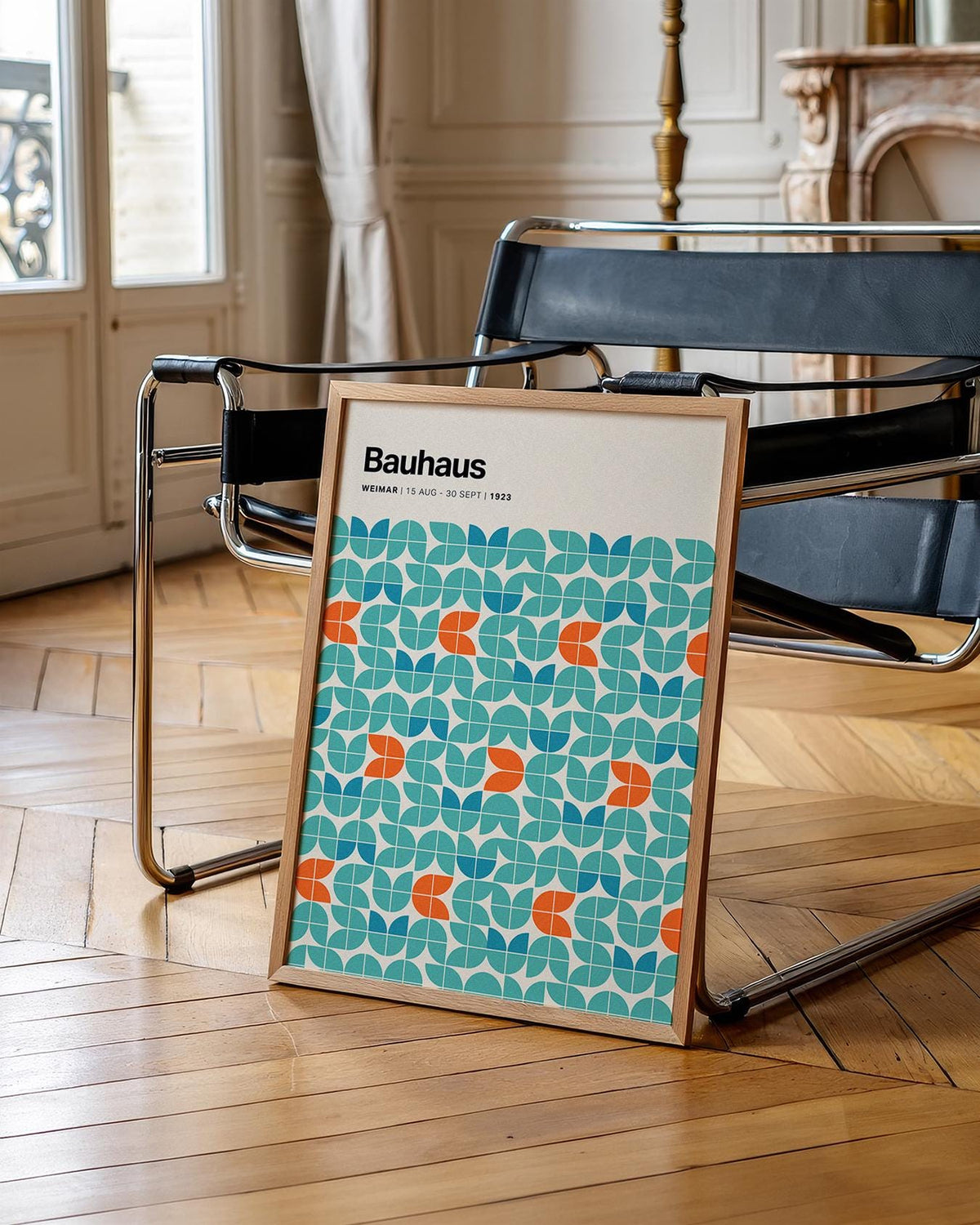 Graphic wall art with modular geometric pattern and blue orange shapes leaning on a modern black chair