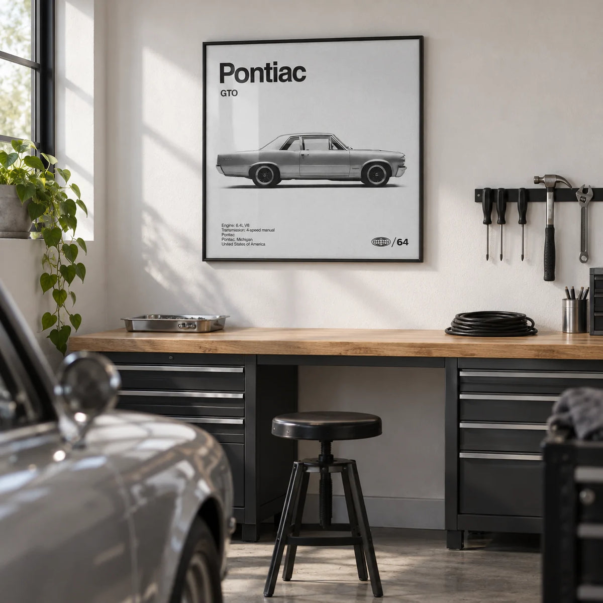 1960s Muscle Car Wall Art, framed on the wall of a tidy domestic garage hobby corner with a smooth white painted wall and sealed concrete floor in a home office