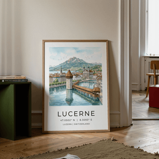 Print leaning on the floor of Lucerne Watercolor Art Print with Chapel Bridge and mountains near a green shelf