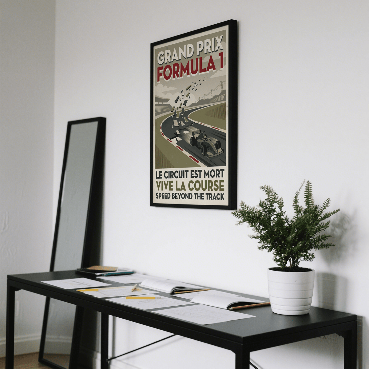 Vintage Grand Prix Art Print on wall above black desk with books and green plant in white pot