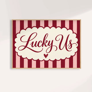 Above bed wall art with Lucky Us in burgundy script on pink and burgundy stripes