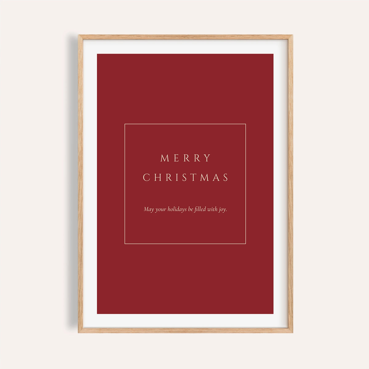 Red Merry Christmas typography print shown on a plain warm wall