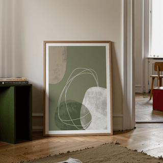 Modern Organic Print leaning on a wall with abstract shapes in green and beige on a wooden floor