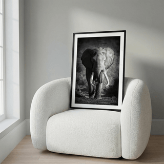 Wildlife Photography Art print leaning on a white armchair showing a black and white elephant with tusks in natural setting